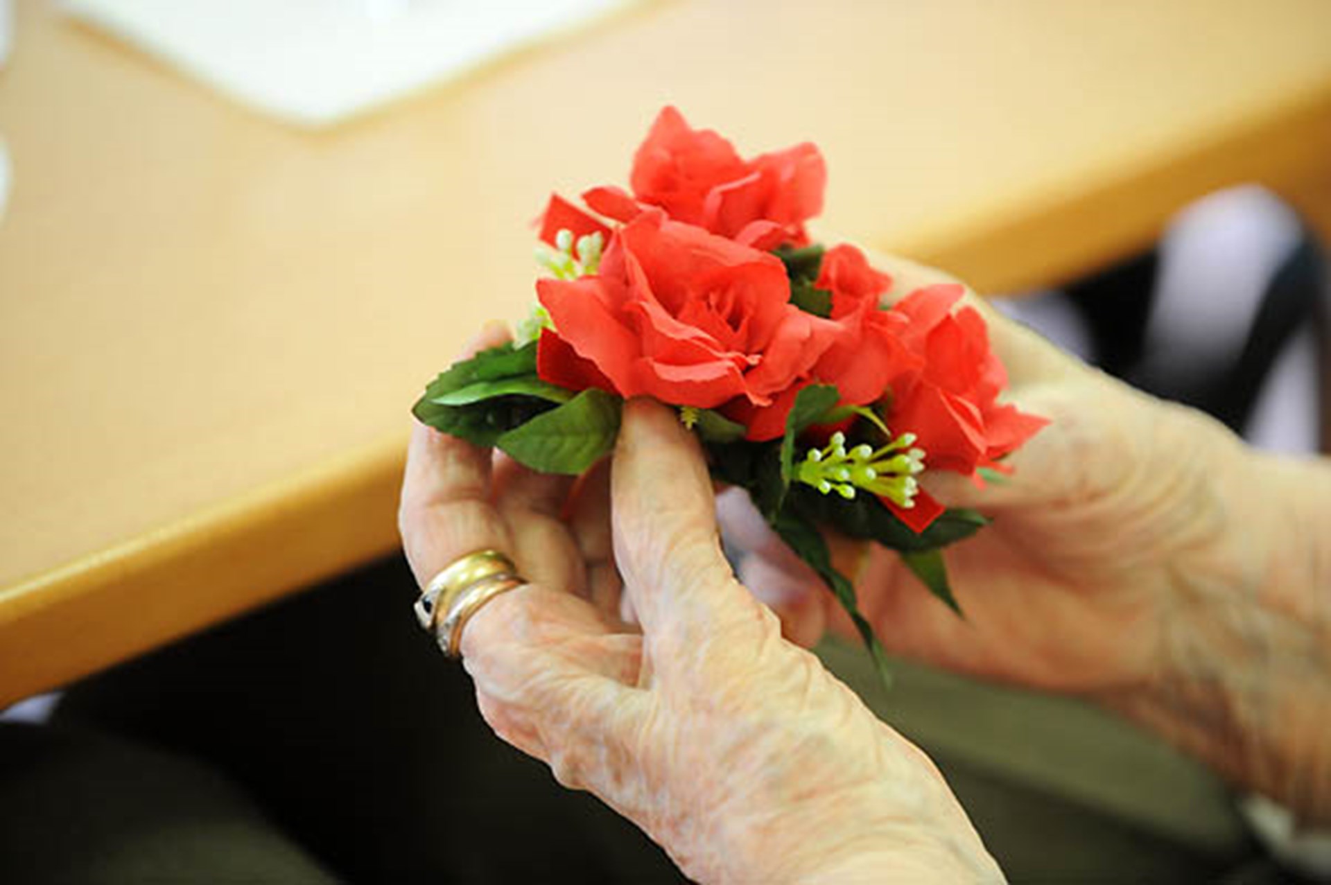 Hand hält Blumengesteck